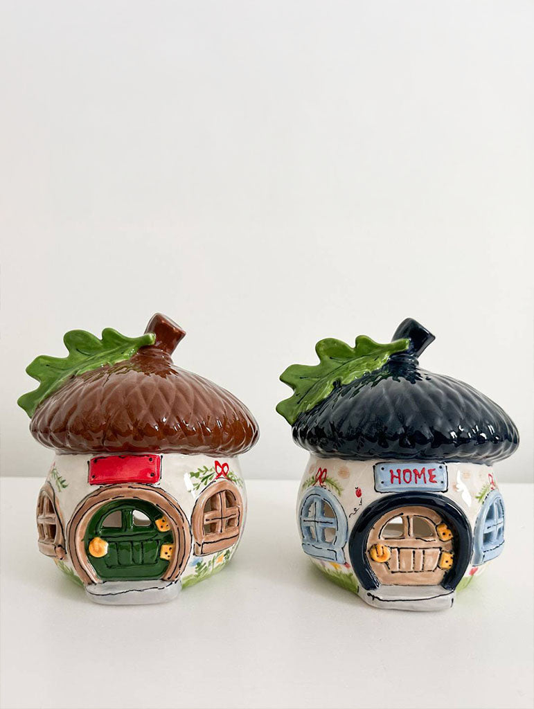 Set of four decorative house-shaped vases with different designs on a white background
